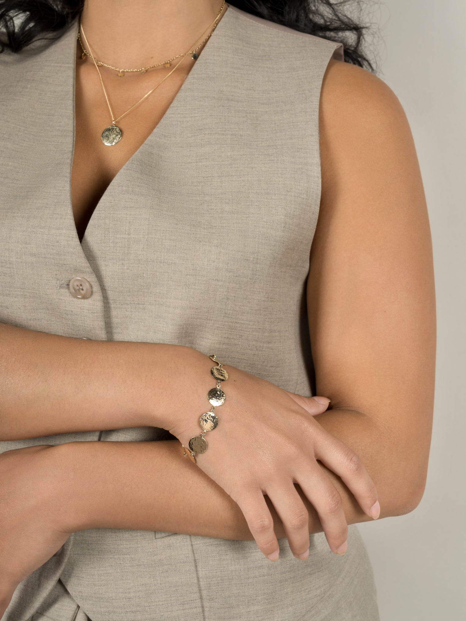 Model wears Lavey London's Solid 9ct Gold Hammered Disc Bracelet, Drop Charm Choker and Hammered Disc Pendant Necklace