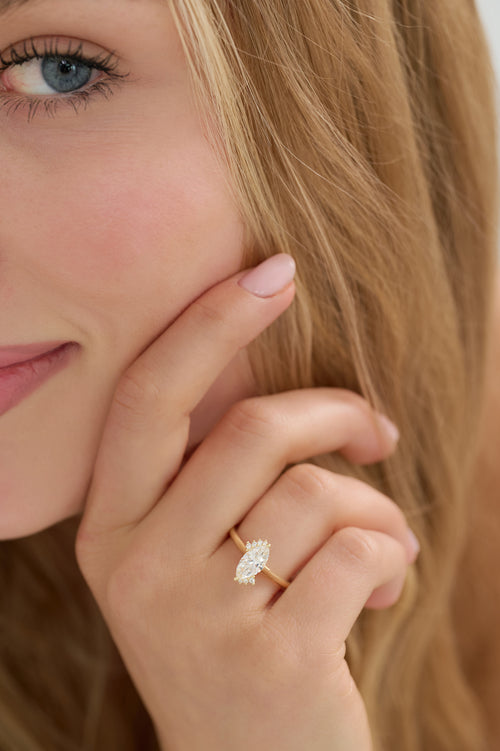 Marquise cut diamond engagement ring with delicate asymmetric diamond cluster
