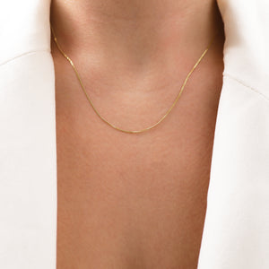 Model wears Lavey London 16 inch solid 9ct gold diamond cut curb chain in white blazer