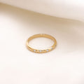 Lavey London's Solid Gold Flush Set Diamond Wedding Band Against A White Fabric Background