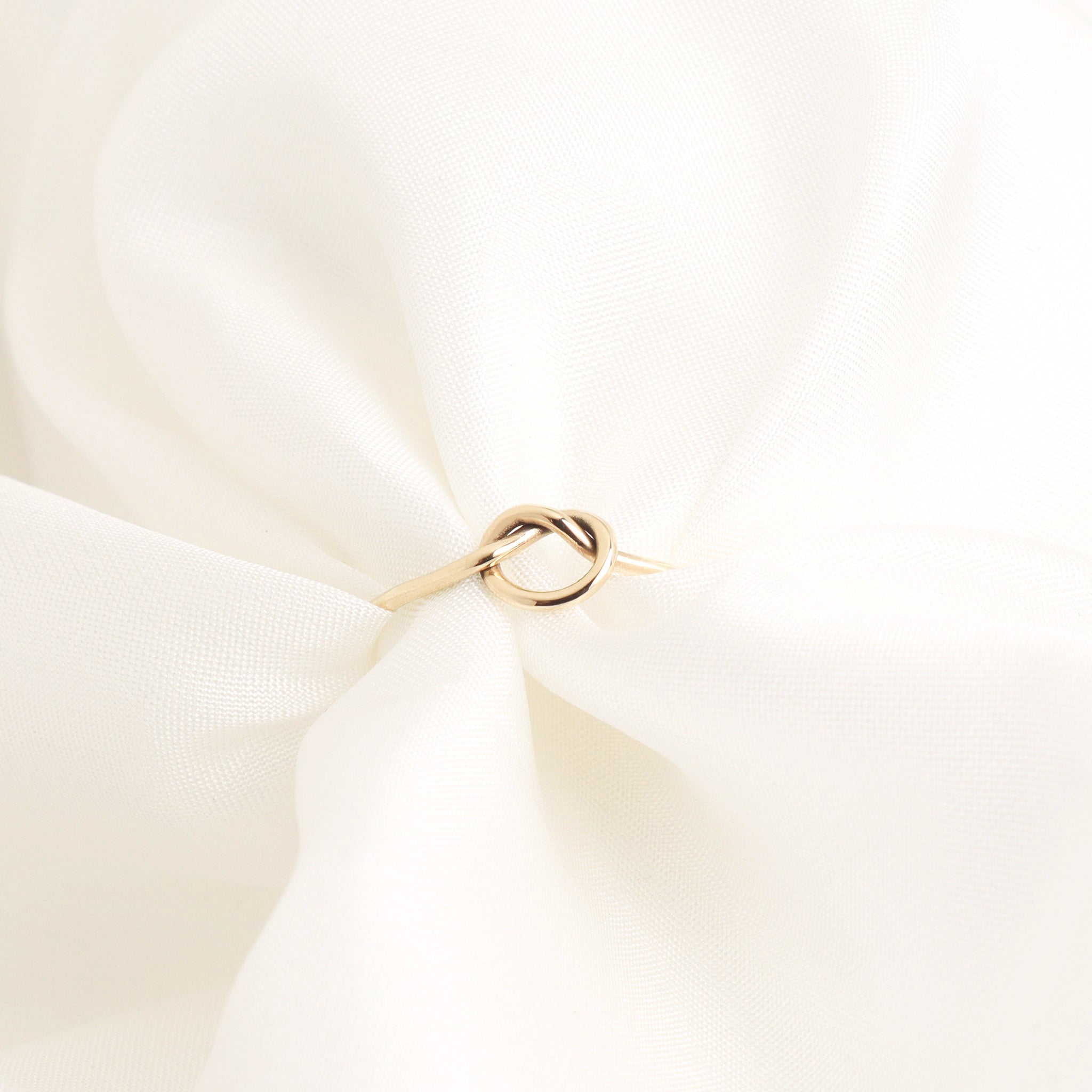 Lavey London's Solid 9ct Gold Love Knot Infinity Ring styled wrapped around scrunched light airy fabric